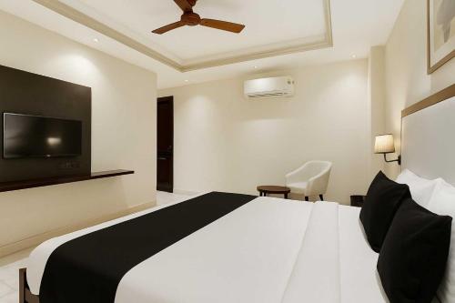 a bedroom with a bed and a flat screen tv at Collection O Udyog Vihar in Gurgaon