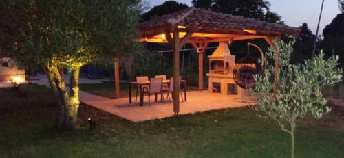 a gazebo with a table and chairs in a yard at night at Fish eye in Nikiti