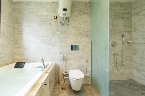 a bathroom with a shower and a toilet and a sink at SaffronStays Sukh Saklana Haveli Suites in Rishīkesh