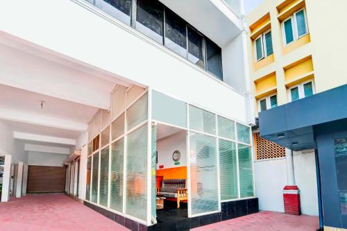 a building with large windows with a table in the distance at Hotel O Chalai Bazaar Near Railway Station in Trivandrum