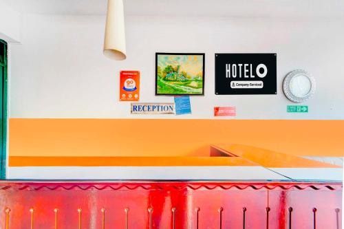 a kitchen with an orange and white wall and a counter at Hotel O Chalai Bazaar Near Railway Station in Trivandrum