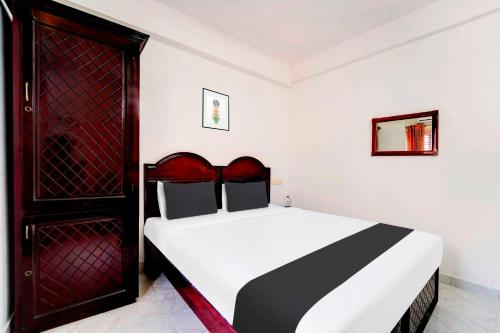 a bedroom with a bed and a red door at Hotel O Chalai Bazaar Near Railway Station in Trivandrum