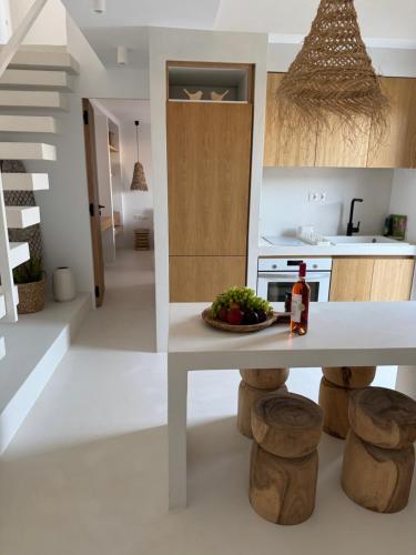 a kitchen with a table with a bowl of fruit on it at The Fortress Antiparos in Agios Georgios