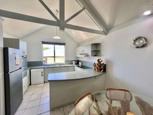 a kitchen with a counter and some chairs in it at Waterfront Unit 4 - Kalbarri WA in Kalbarri