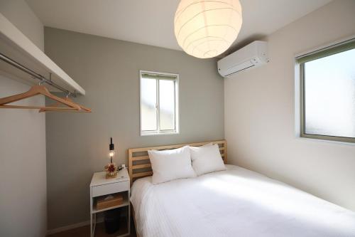 a bedroom with a white bed and a window at Fukuoka Airport 4 in Shime