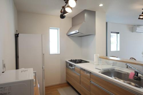 a kitchen with a sink and a stove at Fukuoka Airport 4 in Shime