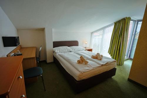 a hotel room with a bed with two teddy bears on it at Götznerhof - Self-Check-in in Innsbruck
