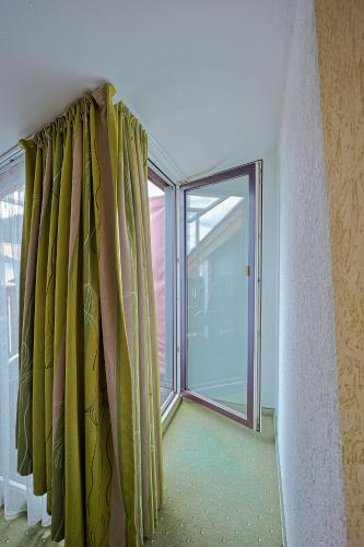 a room with green curtains and a large window at Götznerhof - Self-Check-in in Innsbruck