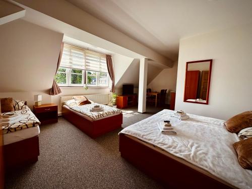 a bedroom with two beds and a window at Penzion G in Šumperk