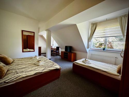 a bedroom with two beds and a window at Penzion G in Šumperk
