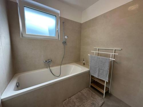 a bathroom with a bath tub and a window at To Had Apartments with Balcony or Terrace, 400m from U-Bahn, Top Location in Vienna
