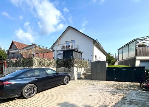 a blue car parked in front of a house at Perfekt für 6! Küche Parkplätze Flughafen in Fahrenzhausen