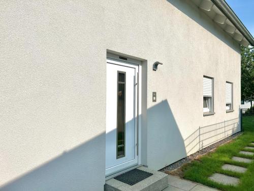 a white door on the side of a house at Perfekt für 6! Küche Parkplätze Flughafen in Fahrenzhausen
