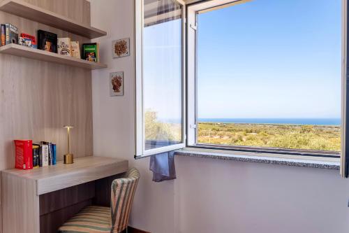 a room with a window with a chair and a desk at Il Giglio Rosa in Sorso