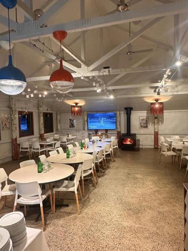 a dining room with tables and chairs and a fireplace at Wellington Forest Cottages & Bar in Wellington Mills