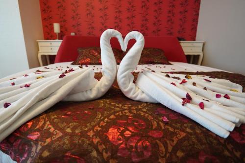 two swansuitsrendered to look like they are kissing on a bed at Grand Karot Hotel in Yalova