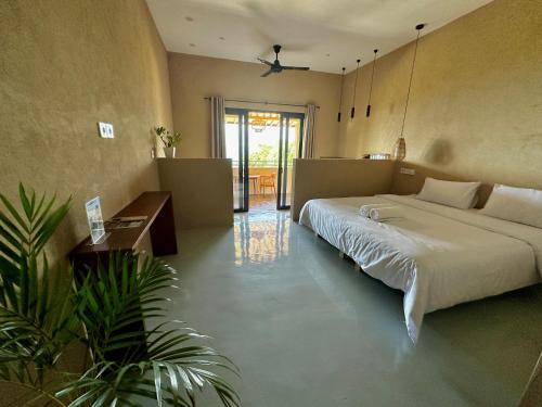 a bedroom with a large bed and a table at Jepun Hill Studios & Amed Jepun Divers in Amed