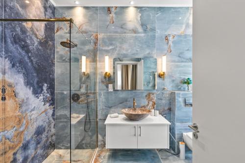 a bathroom with a sink and a shower at Olymp White Palace - The Ultra Luxury Beachfront House in Kissonerga