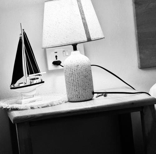 a table with a lamp and a toy boat on it at Villa Océan Gravier Rodrigues in Mt Bois Noir