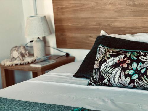 a bed with a pillow and a table with a lamp at Villa Océan Gravier Rodrigues in Mt Bois Noir