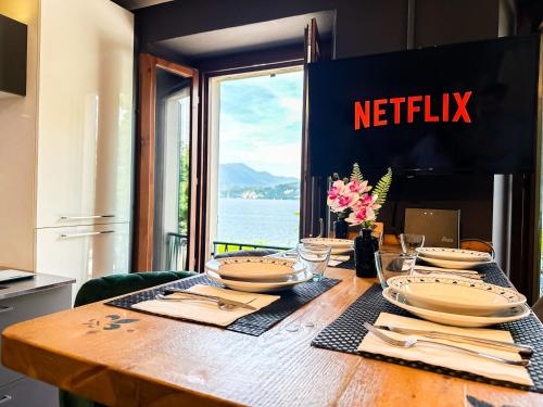 a wooden table with plates and utensils on it at Stresa vista lago con CINEMA e SPIAGGIA in Brisino