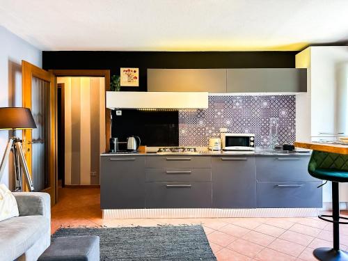 a kitchen with a stove and a microwave at Stresa vista lago con CINEMA e SPIAGGIA in Brisino