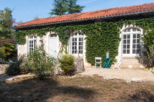a house with ivy on the side of it at Villa au bord de la Charente in Jarnac