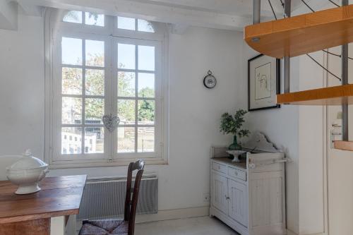 a dining room with a table and a window at Villa au bord de la Charente in Jarnac