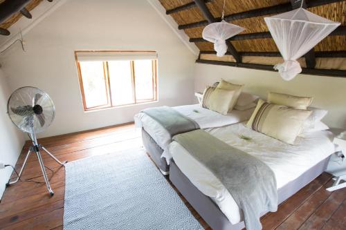 a bedroom with two beds and a fan at Ngama Tented Safari Lodge in Guernsey Nature Reserve