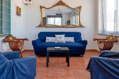 a blue couch in a living room with a mirror at Il Giglio Rosa in Sorso