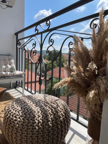 a room with a balcony with a bench and a table at Apartman Boutique Arandjelovac in Arandjelovac