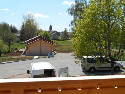 a white truck parked in a parking lot with a building at Le chalet du lac d'étival in Étival
