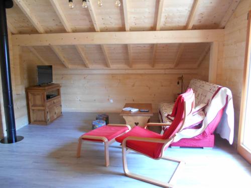 a room with a couch and a chair and a table at Le chalet du lac d'étival in Étival