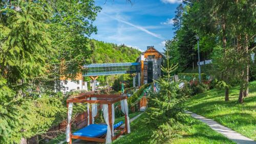 plac zabaw w parku z pociągiem w tle w obiekcie Hotel Czarny Potok Resort SPA & Conference w mieście Krynica Zdrój