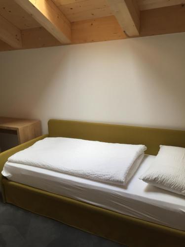 1 cama con sábanas blancas y almohadas en una habitación en R&B La Calzoleria en Mori