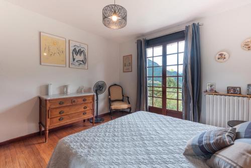 a bedroom with a bed and a dresser and a window at Villa Delb in Arthez-dʼAsson