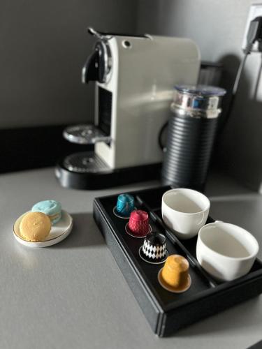 a tray with cupcakes on a counter with a coffee maker at Hotel Awam in Hradec Králové