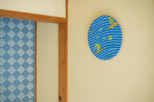 a blue surfboard on a wall next to a window at LAMP Nojiriko The Sauna by the Lake in Shinano