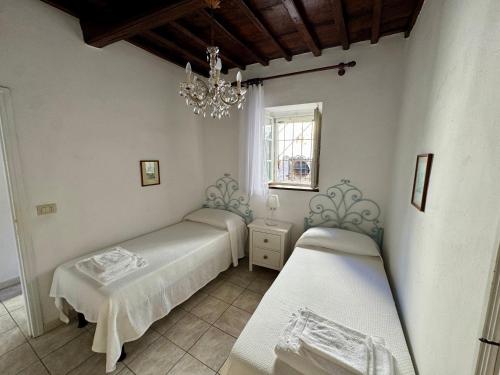 a bedroom with two beds and a chandelier at Casa i capperi in Marciana