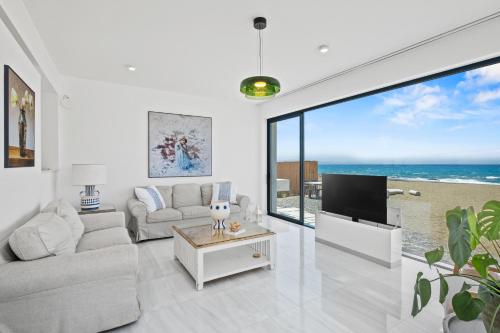 a living room with a couch and a tv at Blue Iris Luxury Beach Villa by Nomads - Steps to Beach in Kato Yialia