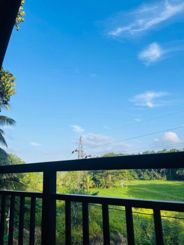 a view of a field from a balcony at Pinna Flower Homestay Cabana in Rambukkana