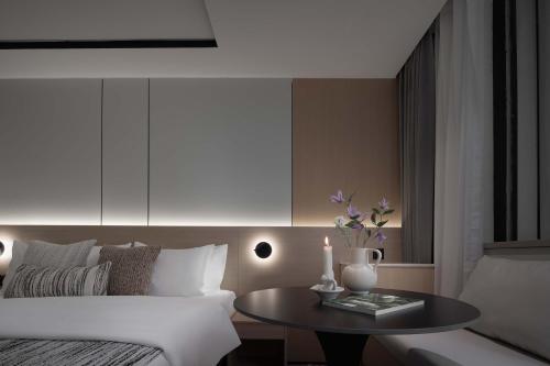 a living room with a bed and a table with a table at Taikoo Li Premier Hotel Chengdu by Enji (Panda & Tianfu) in Chengdu