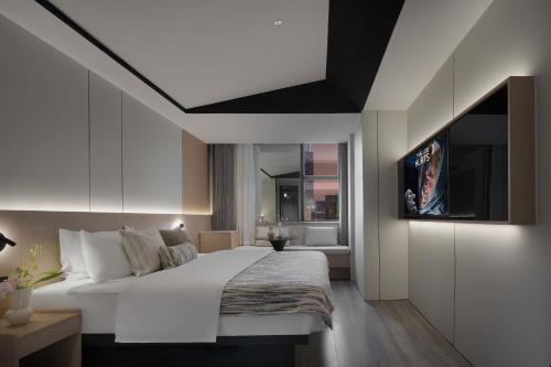 a bedroom with a large white bed and a tv at Taikoo Li Premier Hotel Chengdu by Enji (Panda & Tianfu) in Chengdu
