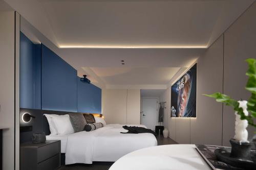 a bedroom with two beds and a cat laying on the bed at Taikoo Li Premier Hotel Chengdu by Enji (Panda & Tianfu) in Chengdu