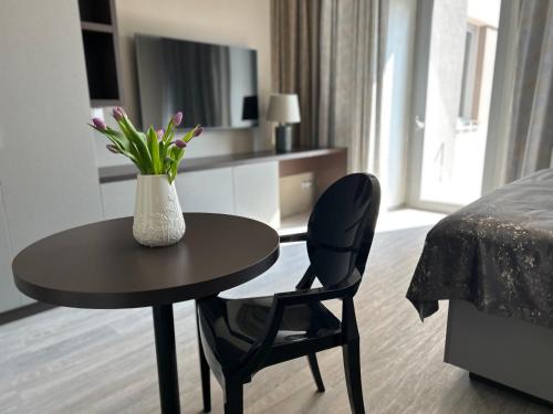 a room with a table and a vase with flowers on it at Hotel Awam in Hradec Králové
