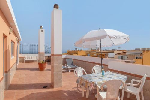 un patio con un tavolo e un ombrellone su un balcone di Ático San Miguel vacacional a Gáldar