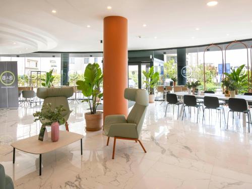 a lobby with chairs and tables in a building at B&B HOTEL Latina in Latina