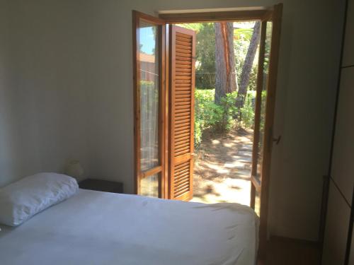 a bedroom with a bed and a sliding glass door at Il Gamberetto in Principina a Mare