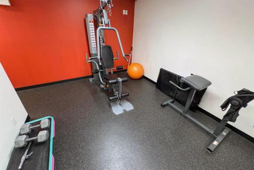 a room with a gym with a treadmill and weights at Ramada by Wyndham Sherwood Park in Sherwood Park