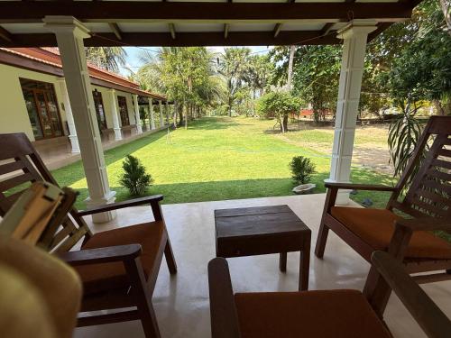 a porch with chairs and a view of a yard at 108 Palms Beach Resort in Trincomalee
